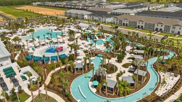 A resort with a large swimming pool, multiple water slides, and a variety of outdoor seating areas. - Disney's Castle Mania Home! 7 Bedroom Villa (Clermont)