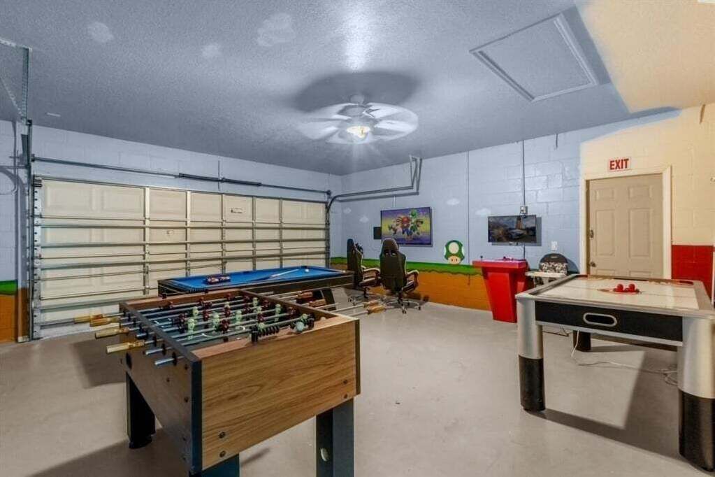 Una habitación con mesa de fútbol, mesa de billar y mesa de ping pong.