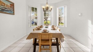 A dining room with a wooden table set for six, a chandelier, and a painting on the wall. - 4 Bed Luxury Quiet & Private Home! 4 Bedroom Villa (Davenport)
