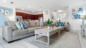 Een moderne woonkamer met een bank, salontafel en decoratieve objecten.