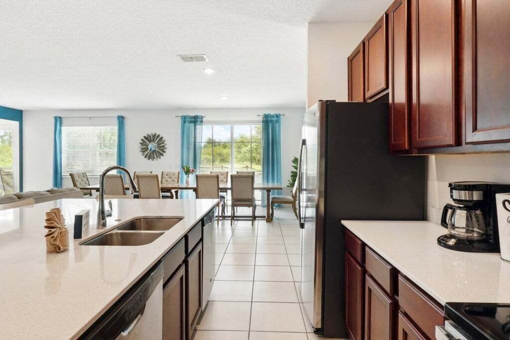 A modern kitchen with a central island, built-in cabinets, and a coffee maker.