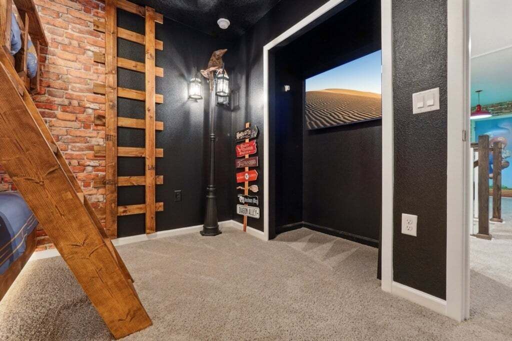 Een kamer met een bakstenen muur, een houten ladder, een zwarte deur en een bord met verschillende richtingaanwijzingen.