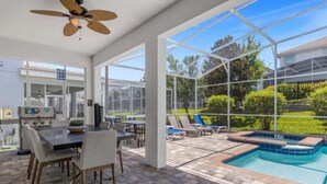 A covered patio with a pool, outdoor seating, and a view of the surrounding landscape. - Star Wars & More Large Private Pool Lanai Home! 6 Bedroom Villa (Davenport)