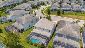 A residential area with houses featuring large glass windows and a swimming pool. - Star Wars & More Large Private Pool Lanai Home! 6 Bedroom Villa (Davenport)
