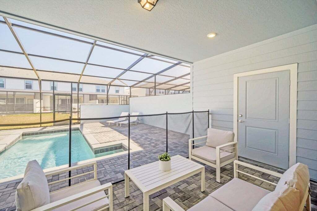 A rooftop patio with a swimming pool, outdoor seating, and a glass ceiling.