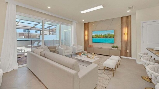 A modern living room with a sofa, coffee table, and TV. - Luxury Home With Splash Pool 5 Bed Townhome! 5 Bedroom Townhouse (Clermont)