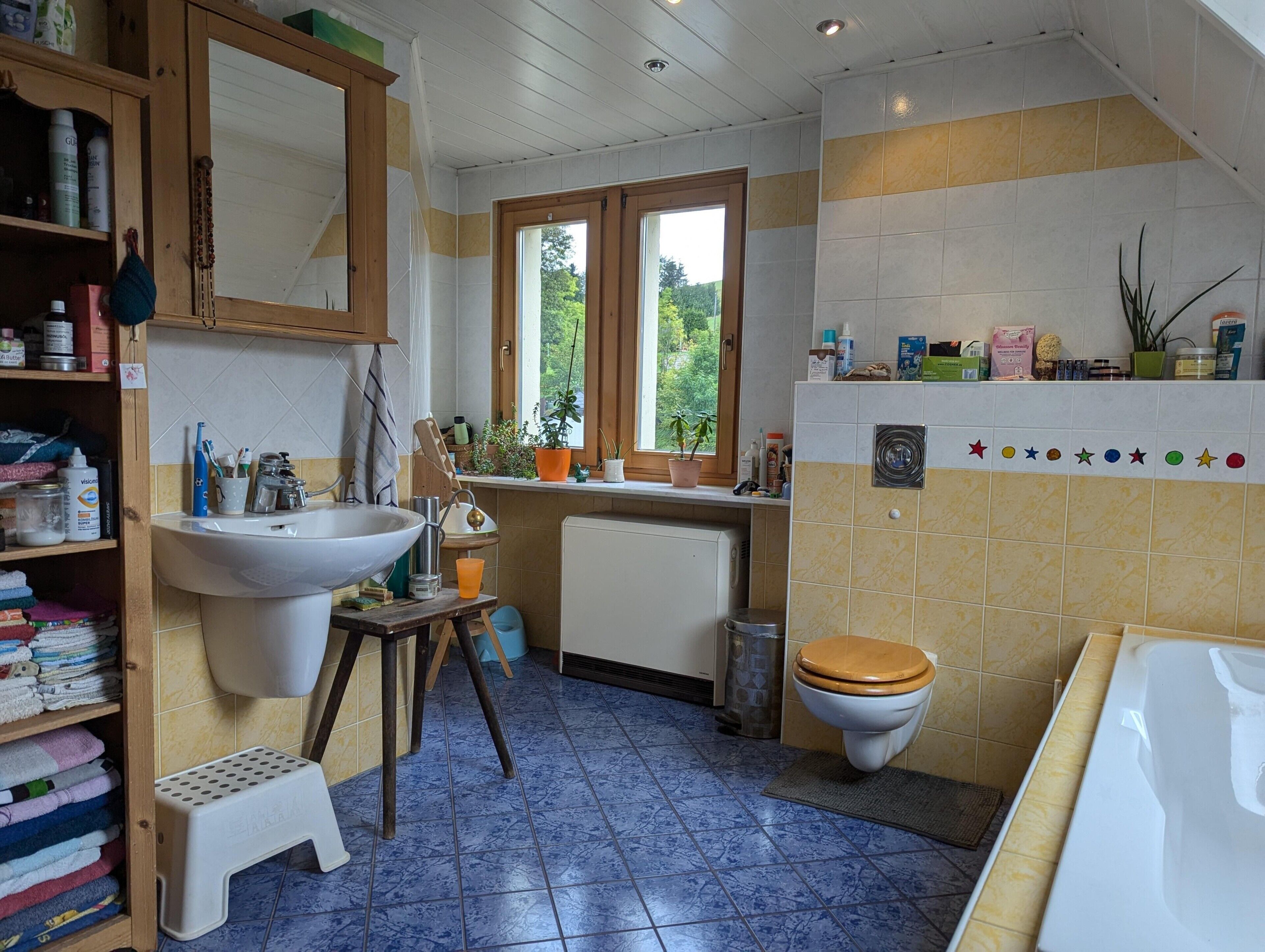 Une salle de bain avec un lavabo, des toilettes et une fenêtre.