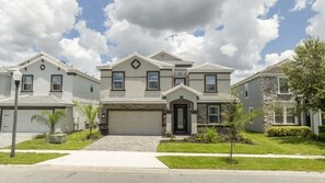 A residential building with a garage, a front entrance, and a symmetrical facade. - The Most Stunning Home With Everything You Want! 8 Bedroom Villa (Davenport)