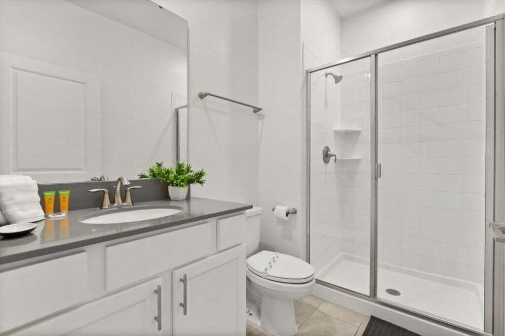 Un baño moderno con ducha, inodoro y lavabo.