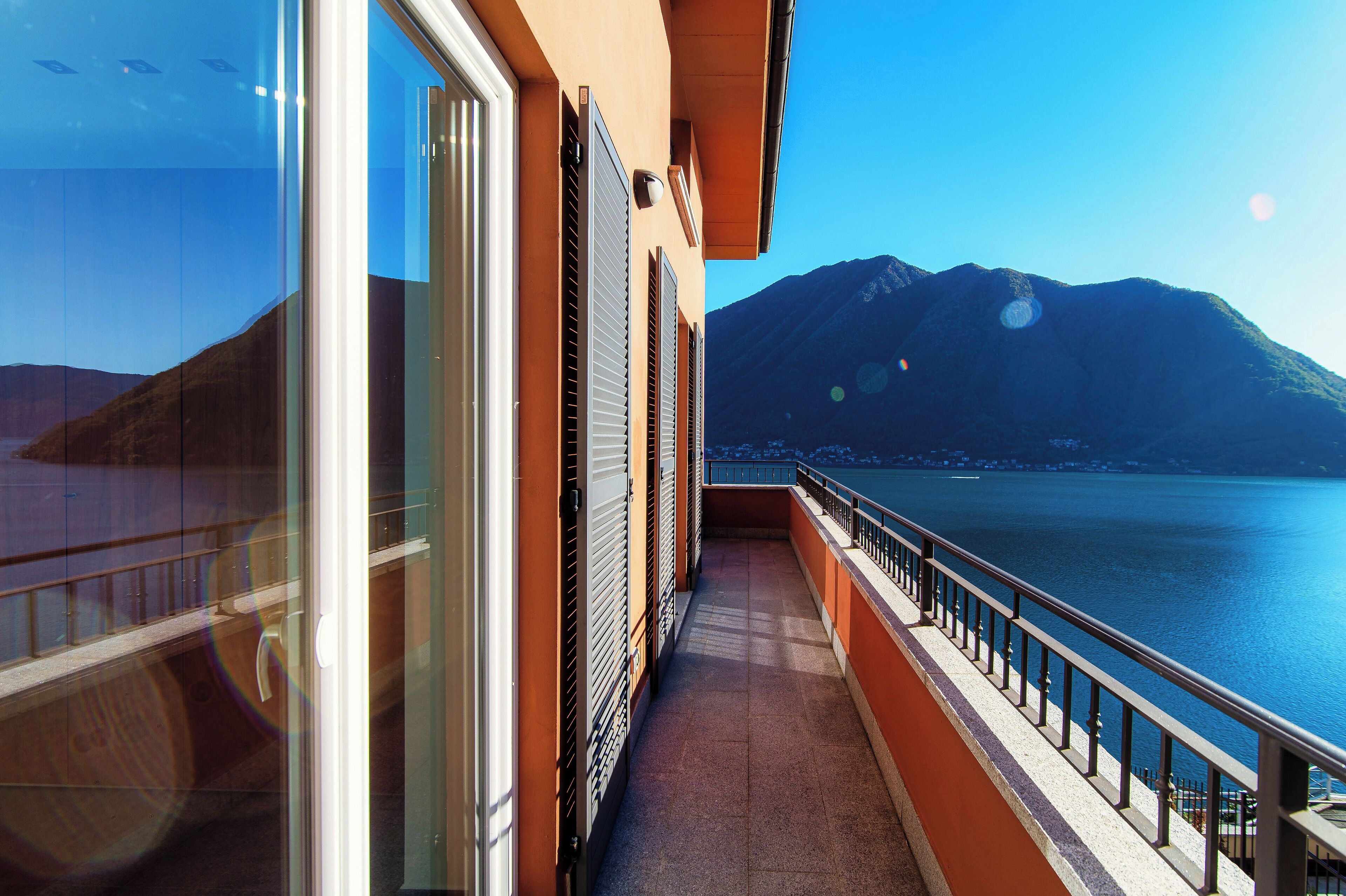 A balcony with a view of a lake and mountains.