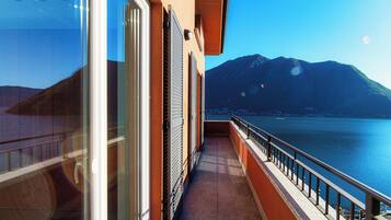 A balcony with a view of a lake and mountains.