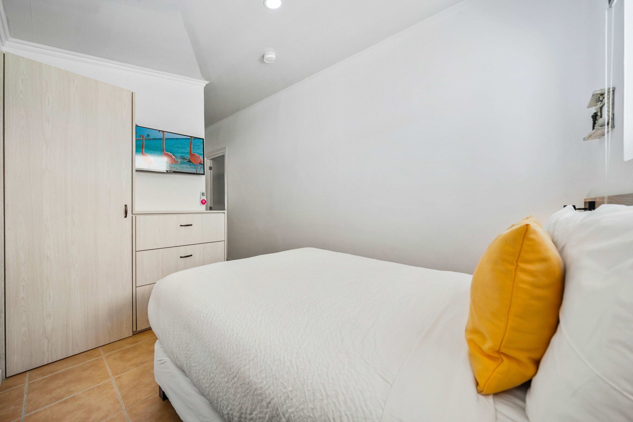 Une chambre à coucher avec un lit, une armoire et un tableau accroché au mur.