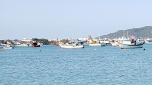 A calm body of water with boats and a distant shoreline. - LM64 Lobster House in Bombinhas for 15 people Share Save (Bombinhas)