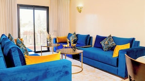 Ein Wohnzimmer mit blauen Sofas, einem Couchtisch und Zierkissen.