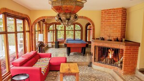 A cozy room with a red sofa, a pool table, and a fireplace. - Hotel Campestre Rancho La Lechería (Cali)