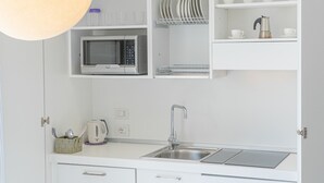 A compact kitchen with a microwave, sink, and storage cabinets. - Residence with panoramic swimming pool in Porto San Paolo just 850 mt from the sea (Porto San Paolo)