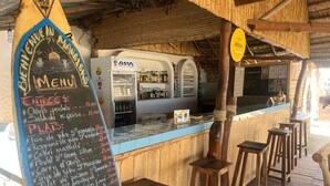 A restaurant with a chalkboard menu, wooden bar stools, and a rustic interior. - Villa Maroloko (Ifaty)