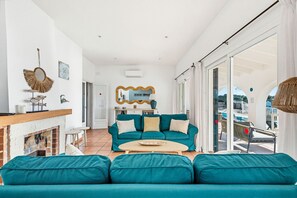 Una sala de estar moderna con un sofá color turquesa, una mesa de centro y una chimenea.