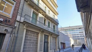 Une rue étroite, avec un immeuble dont le rez-de-chaussée présente une entrée signalée par les numéros « 3-5 ».