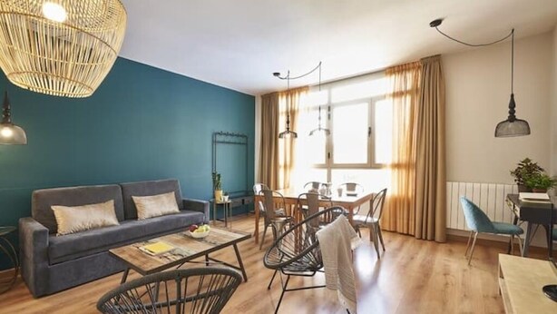 Un salon moderne avec un canapé, une table basse et un coin repas.