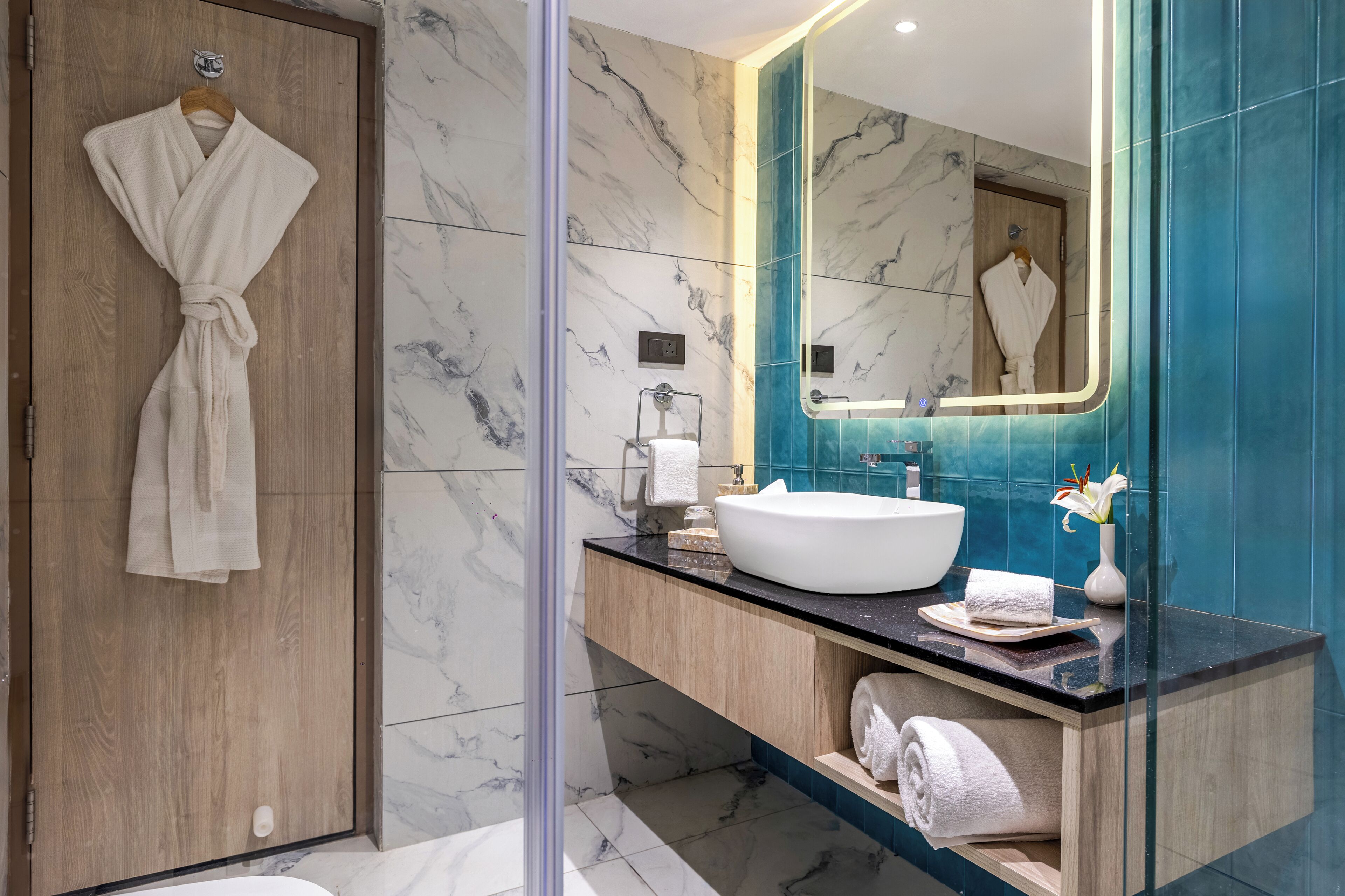 Un bagno moderno con un mobile contenitore in legno, un lavandino bianco e uno specchio grande.