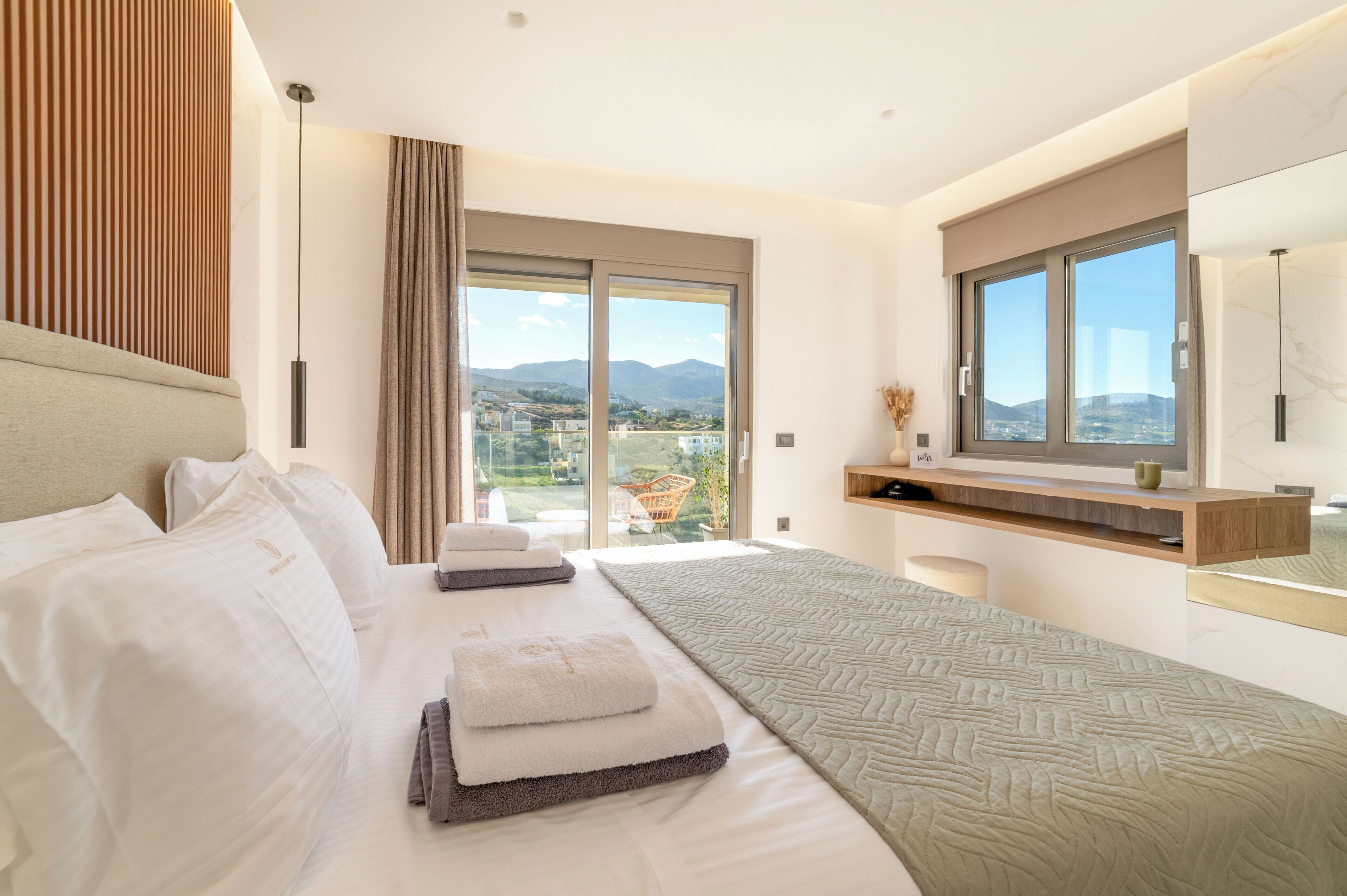 Une chambre d’hôtel moderne dotée d’un grand lit, d’un coin salon avec vue et d’un balcon.