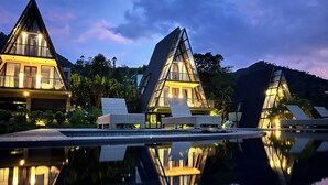 A modern resort with triangular architecture, a pool, and lounge chairs. - Tamblingan Village   (Munduk)