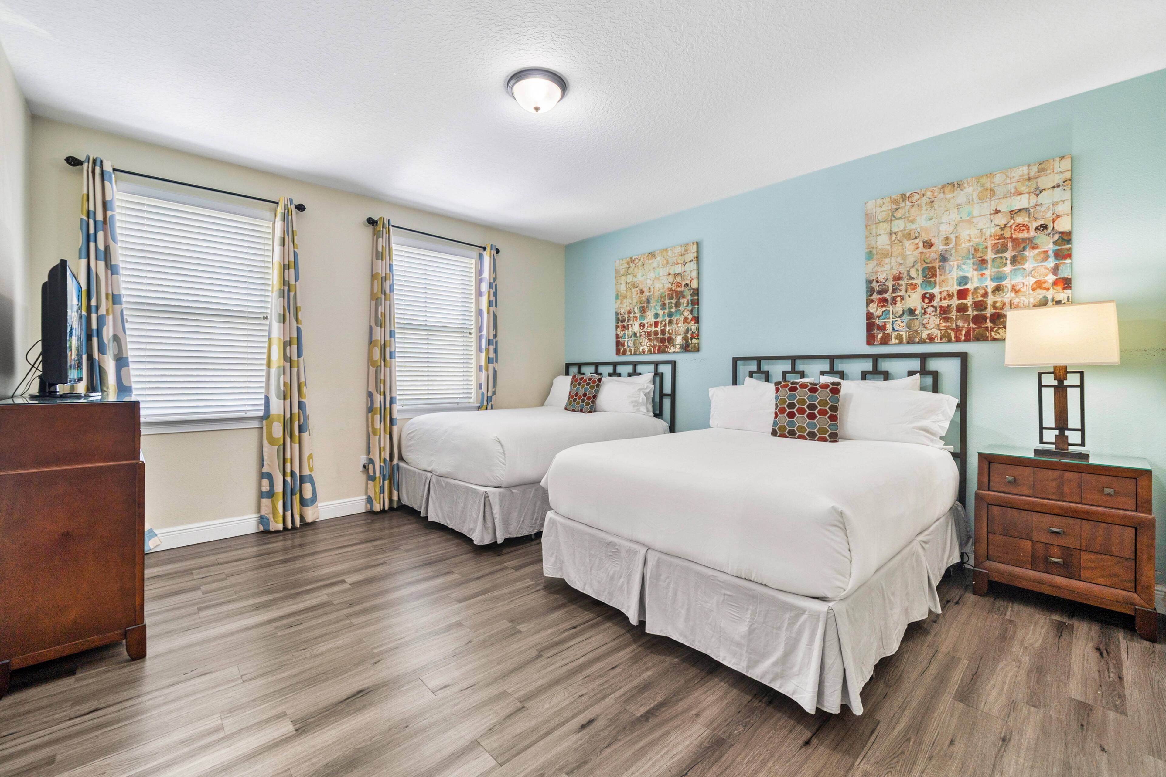Ein Hotelzimmer mit zwei Betten, einem Holzkapfen, einem Nachttisch und Bildern an der Wand.