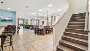 A spacious kitchen with a dining area, a staircase, and a view of the outdoors. - Pool Table, Arcade, Foosball, Resort-style Pool: Sunny Villa (Kissimmee)