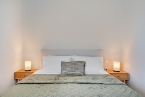 A bed with a quilt, two bedside lamps, and a nightstand with a drawer. - Apartment 'One Bedroom  6' with Sea View, Wi-Fi and Air Conditioning (skoutari)