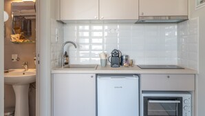 Una cucina compatta con lavastoviglie, forno e lavello.