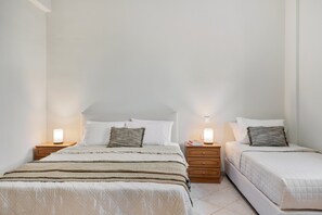 Habitación doble con dos camas, mesitas de noche y lámparas de pared.