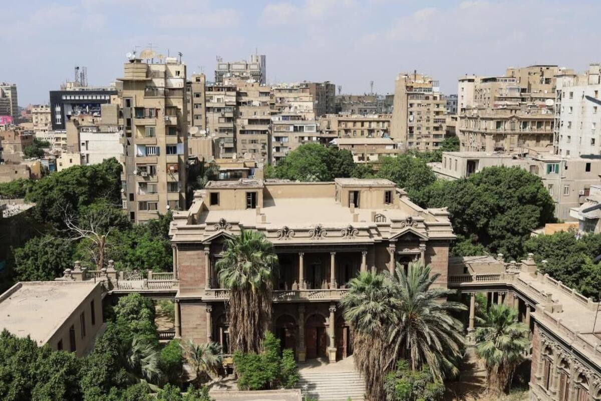 A historic building with classical architecture, surrounded by dense urban residential buildings.