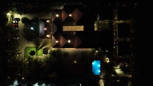 An aerial view of a modern building with a geometric facade, surrounded by trees and a swimming pool. - D'WAYFARER INN Resort  (Erode)