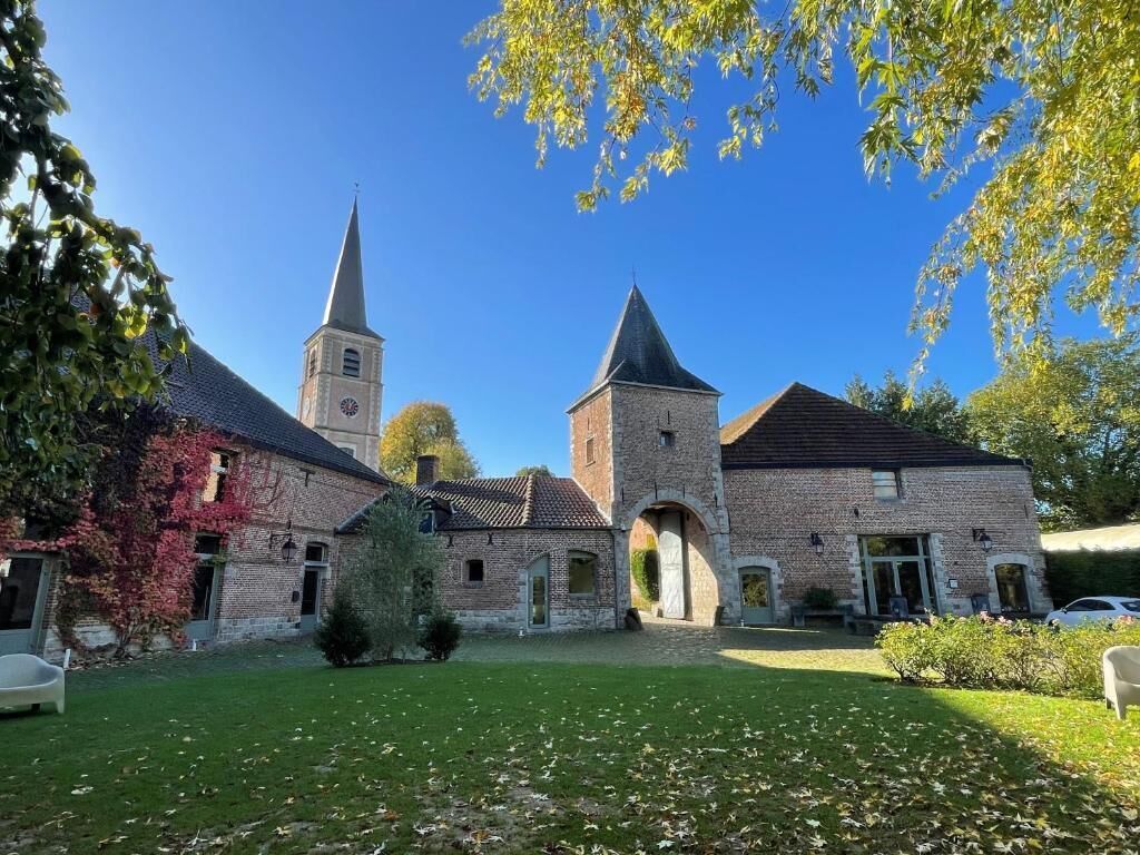 Un patio con una iglesia, un campanario y un edificio de ladrillo.