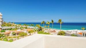 Um resort com vista para o oceano, palmeiras e uma praia.