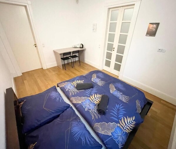 Un dormitorio con cama, escritorio y silla.