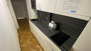 Una cocina moderna con encimera negra, microondas integrado y estufa.