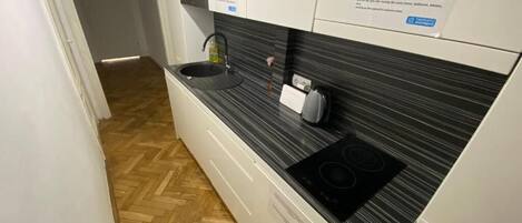 A modern kitchen with a black countertop, a built-in microwave, and a stove.