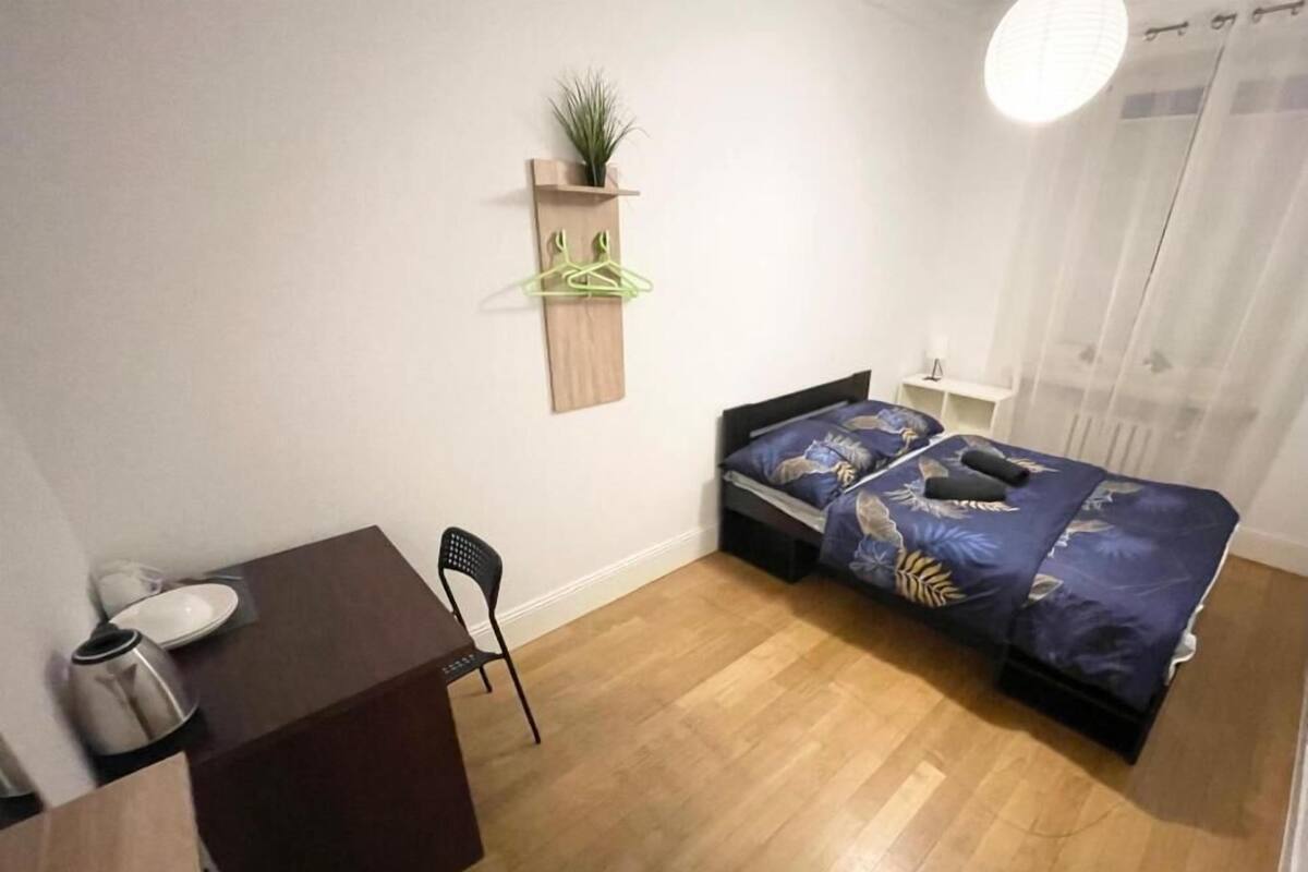 A small, tidy room with a bed, a desk, and a chair.