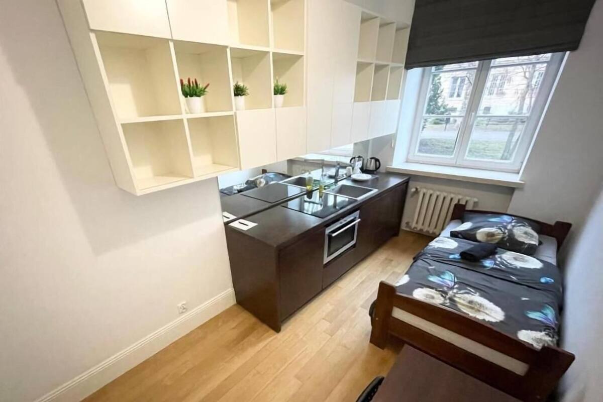A compact kitchen with a built-in island, a dining table, and a window with a view.