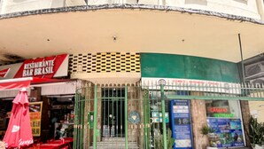 Restaurante con terraza, entrada con portón y un cartel visible para un bar.