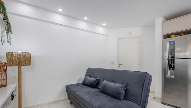 A modern living room with a grey sofa, a floor lamp, and a stainless steel refrigerator. - Apt w/ Barbecue Grill 750m From the Beach Evp0504 (Itapema)