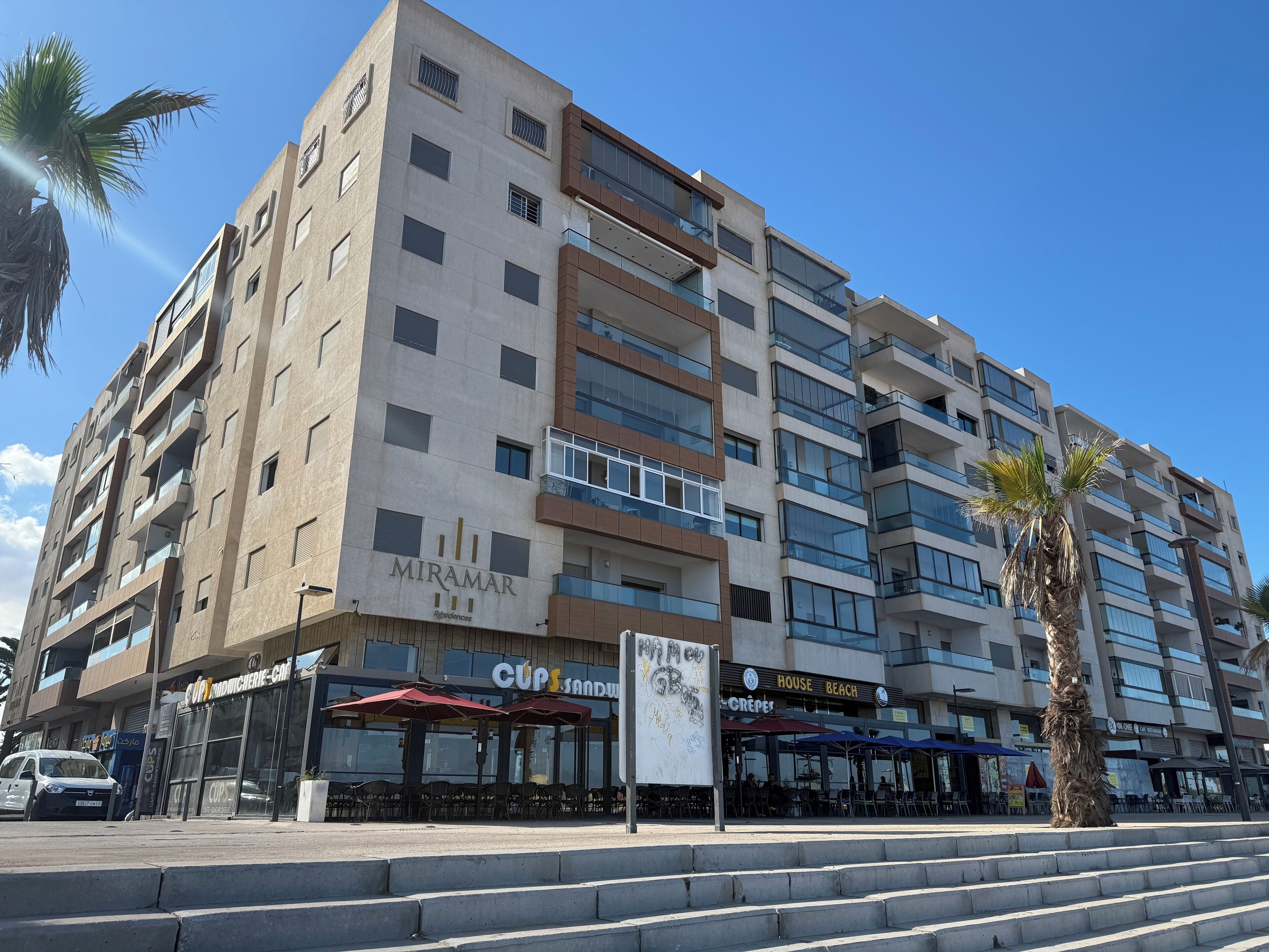 A multi-story building with a sign for 'MIRAMAR Residences'.