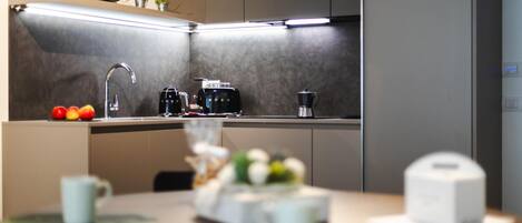 A modern kitchen with a microwave, coffee maker, and sink.