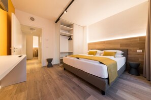 Una camera d'albergo moderna con un letto, un comodino e una cabina armadio.