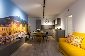 Una cucina moderna con zona pranzo, un divano giallo e un orologio a parete.