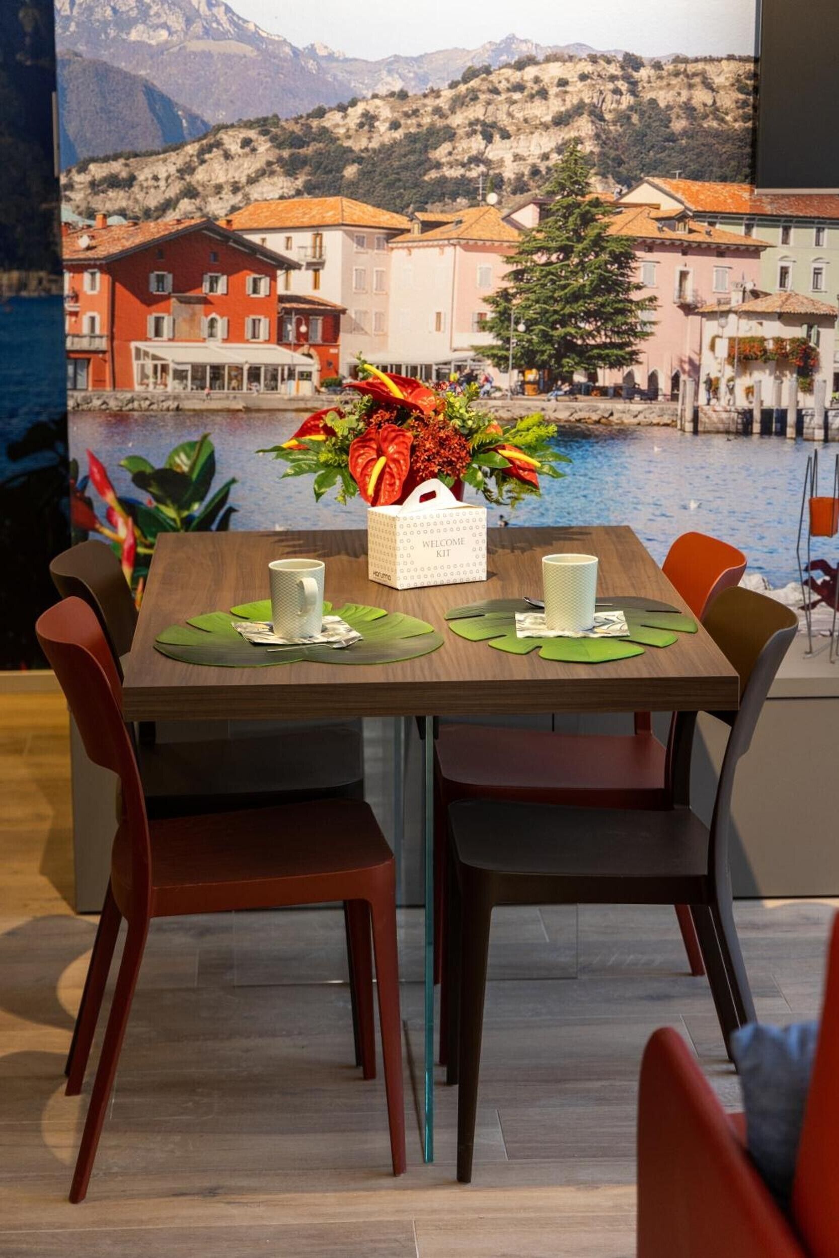 A dining table with a welcome kit, green placemats, and two white cups.