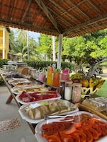Uma mesa de buffet com diversos alimentos e acompanhamentos.