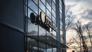 Un edificio moderno con facciata in vetro e un cartello che recita 'Jocushotel'.